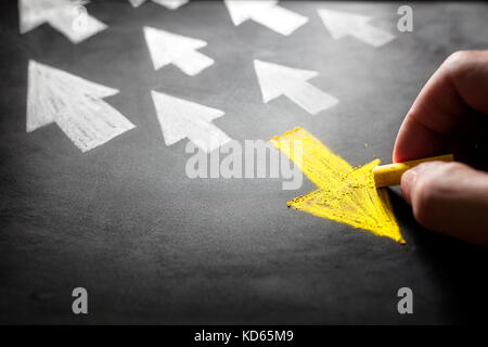 Individuality chalk arrow going a different direction on blackboard Stock Photo