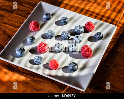berries background. Blueberry and raspberry on white plate Stock Photo