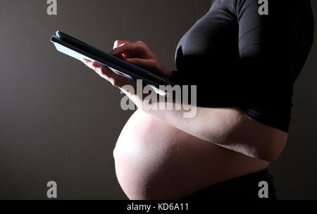 pregnant teenager using ipad tablet computer