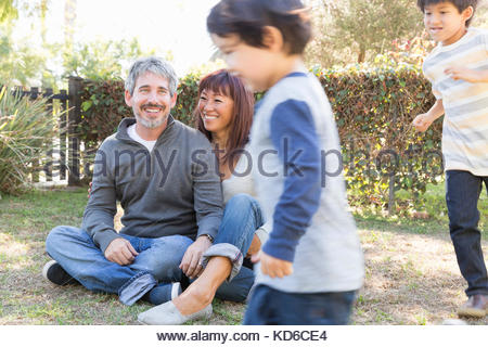 Happy young family sitting and playing in grass