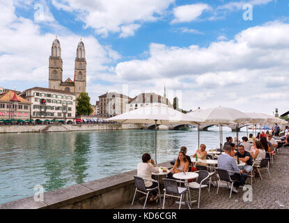 Cafe on the banks of the River Limmat looking towards the Grossmünster, Zürich, Lake Zurich, Switzerland Stock Photo