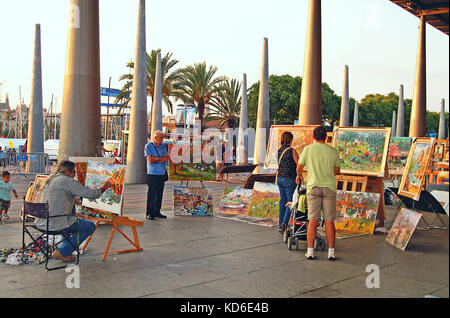 Spanish street artist painting and displaying his oil paintings, near the Ramblas in Barcelona Spain Stock Photo