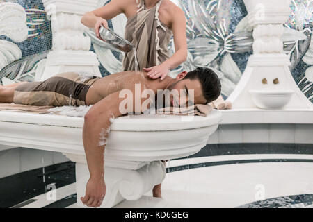 Relaxed man lying down on hot marble bed during traditional Turk Stock Photo