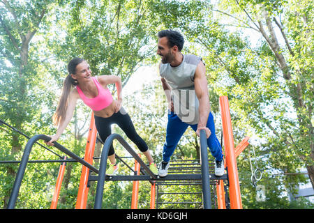 Young fit woman and her partner practicing plank exercise during Stock Photo