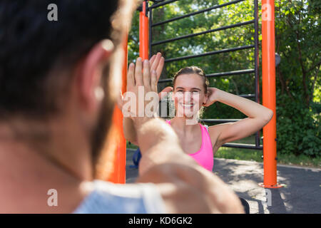 Cheerful young woman giving high-five to her partner while doing Stock Photo