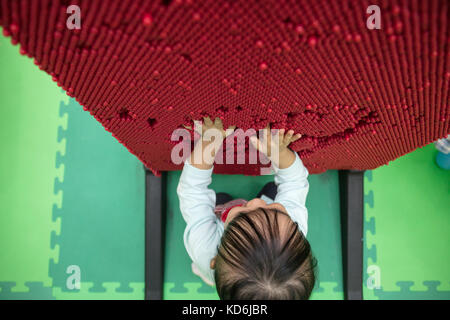Asian Chinese little girl playing pin board at indoor playground Stock Photo