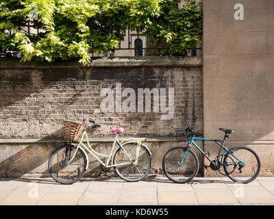 Two bicycles leaning up against the wall of Sidney Sussex College part of Cambridge University UK in autumn sunshine Stock Photo