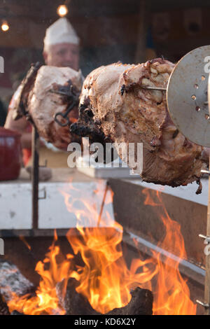 A pig being roasted on the stick using charcoal. Stock Photo