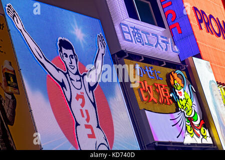 JAPAN, OSAKA, JUL 01 2017, The Glico running man on a race track. Glico Man sign with many other neon ads in the Dotonbori district, Osaka, Japan Stock Photo