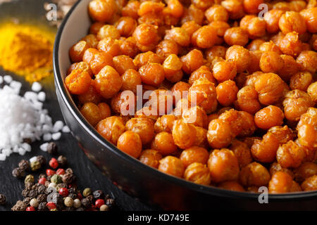 Crispy fried chickpeas with spices macro in a bowl on the table. horizontal Stock Photo