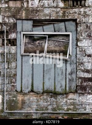 Dilapidated wooden window frame on condemned derelict factory building ...