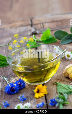 Various dried meadow herbs and herbal tea on old wooden table. fresh medicinal plants and in bundle. Preparing medicinal plants for phytotherapy and health promotion Stock Photo