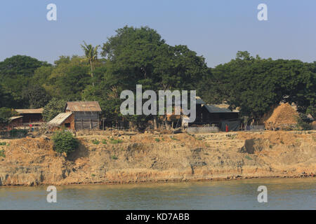 A Buddhist Monk walks along the riverbank at Ngazun Village on the Irrawaddy River in Myanmar (Burma). Stock Photo