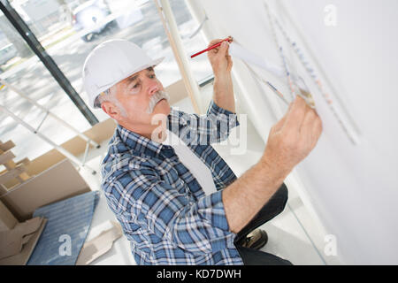 Contractor using folding ruler on the wall Stock Photo