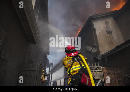 Anahiem Hills, CA, USA. 9th Oct, 2017. The Canyon Fire 2 burns in Anaheim Hills Monday October 9th, 2017. At least six homes were burning by early afternoon as strong Santa Ana Winds forced evacuations in Orange County. Credit: Stuart Palley/ZUMA Wire/Alamy Live News Stock Photo