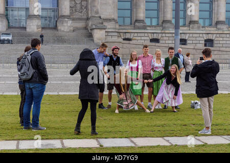 Young Germans taking photo in front of the Reichstag building in Berlin, Germany Stock Photo