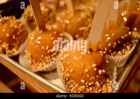 Peanut covered caramel apples on a wooden stick for sale at Seaquist Orchards Farm Market, Sister Bay, Door County, Wisconsin. Stock Photo