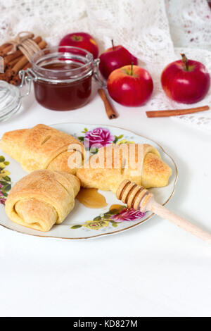 Breakfast. Croissants, honey and apple on whote wooden background. Italian breakfast. Tasty food. Bakery products. Stock Photo