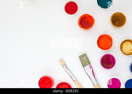 set of brightly colored paints with brushes on white table backround top view Stock Photo