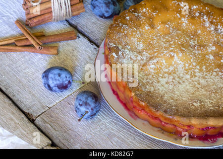 Still life with a homemade plum pie on rustic white wooden background. Stock Photo