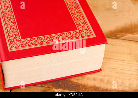 Closed red book on wooden background Stock Photo