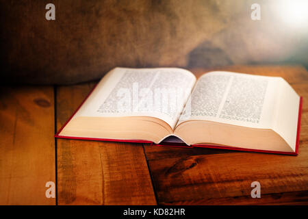 Old Book With Lights On Vintage wooden Table Stock Photo