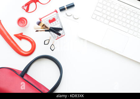 Creative flat lay of laptop, cosmetic in shopping cart and Halloween accessories on white background, Online shopping concept Stock Photo