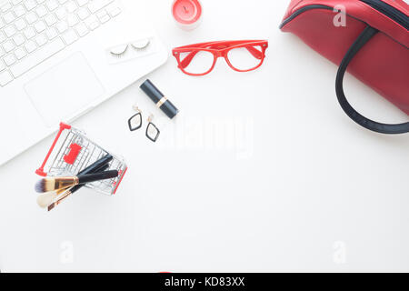 Beauty items in shopping cart with laptop computer on white background, Online shopping Stock Photo