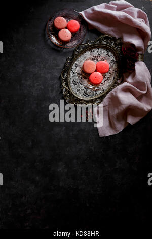 Macarons on a silver platter against a dark bckground Stock Photo