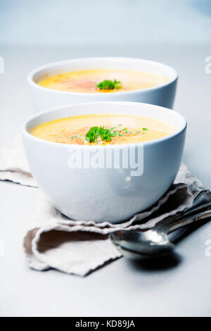 Pumpkin cream soup in bowl over grey concrete background, copy space, vertical composition Stock Photo
