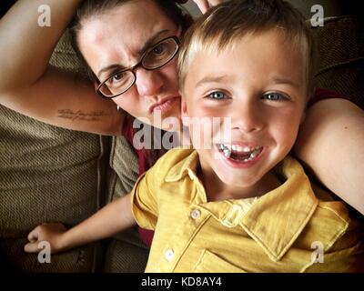 Mother and her son siting on couch taking a selfie Stock Photo