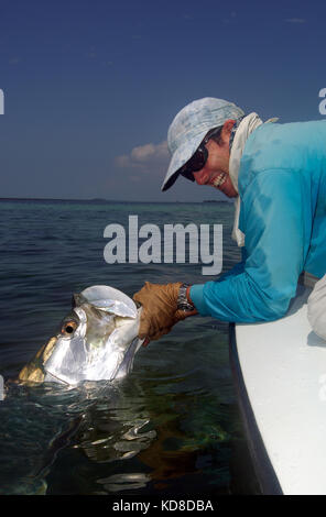 A fisherman lands a tarpon caught while fly fishing the Florida Keys near Key West Stock Photo