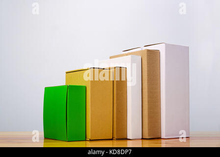 Group of cardboard box different color and size, pile of package made from paper for mock-up on bright wooden table with copy space. Stock Photo