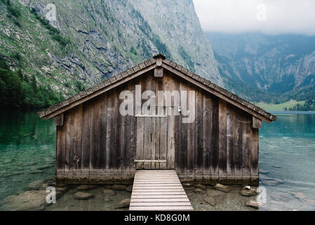 Wooden cottage in beautiful lake in the Alps with misty mood. Stock Photo