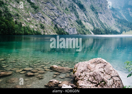 Scenic view of Obersee lake in Bavaria a misty day. Panorama Stock Photo