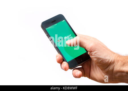 A man using the Tripadvisor app on a mobile phone Stock Photo