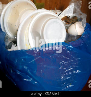 Rubbish bin with plastic bag and various household items, Indoor closeup shot Stock Photo