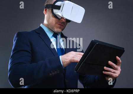 Pleasant handsome businessman working on a tablet Stock Photo