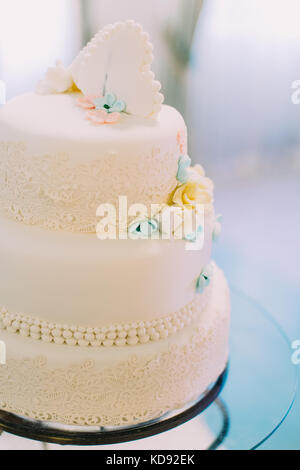 Close-up view of the wedding cake decorated with blue and yellow flowers.