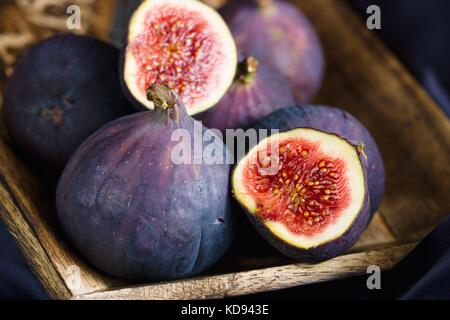 Close up on blue ripe figs in wooden bowl Stock Photo