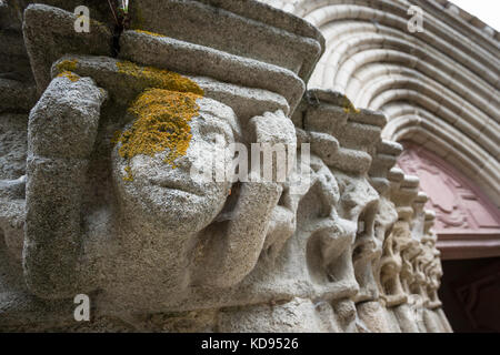 EYMOUTIERS, FRANCE - JUNE 27, 2017: Detail of the old stone sculptured faces next to the main entrance to the Collégiale Saint-Etienne d'Eymoutiers. Stock Photo