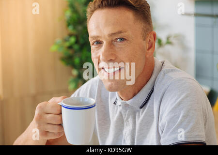 Joyful happy man having tea Stock Photo