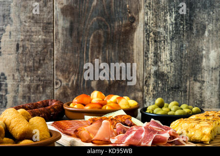 Traditional spanish tapas. Croquettes, olives, omelette, ham and patatas bravas on wooden table