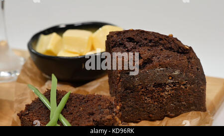 Diced butter, caviar, black bread. Bowl of red caviar with spoon served with sliced bread, butter and herbs on white background. Wholegrain bread, butter and red caviar, white background Stock Photo