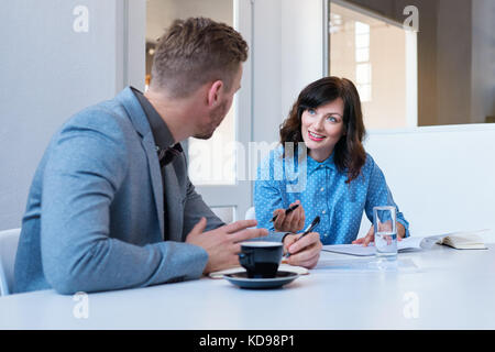 Smiling coworkers talking together in an office meeting room Stock Photo