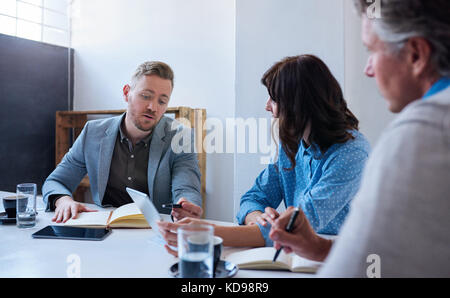 Work colleagues having a meeting together in an office Stock Photo