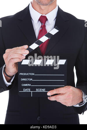 Close-up Of A Businessman Holding Clapperboard Over White Background Stock Photo