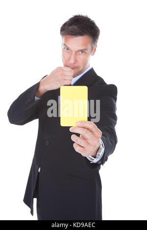 Portrait Of Mature Businessman Showing Yellow Card Over White Background Stock Photo