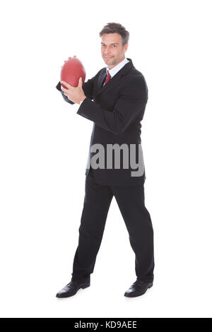 Portrait Of Mature Businessman Holding Rugby Ball Over White Background Stock Photo