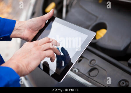 Close-up Of A Car Mechanic Using Digital Tablet Stock Photo